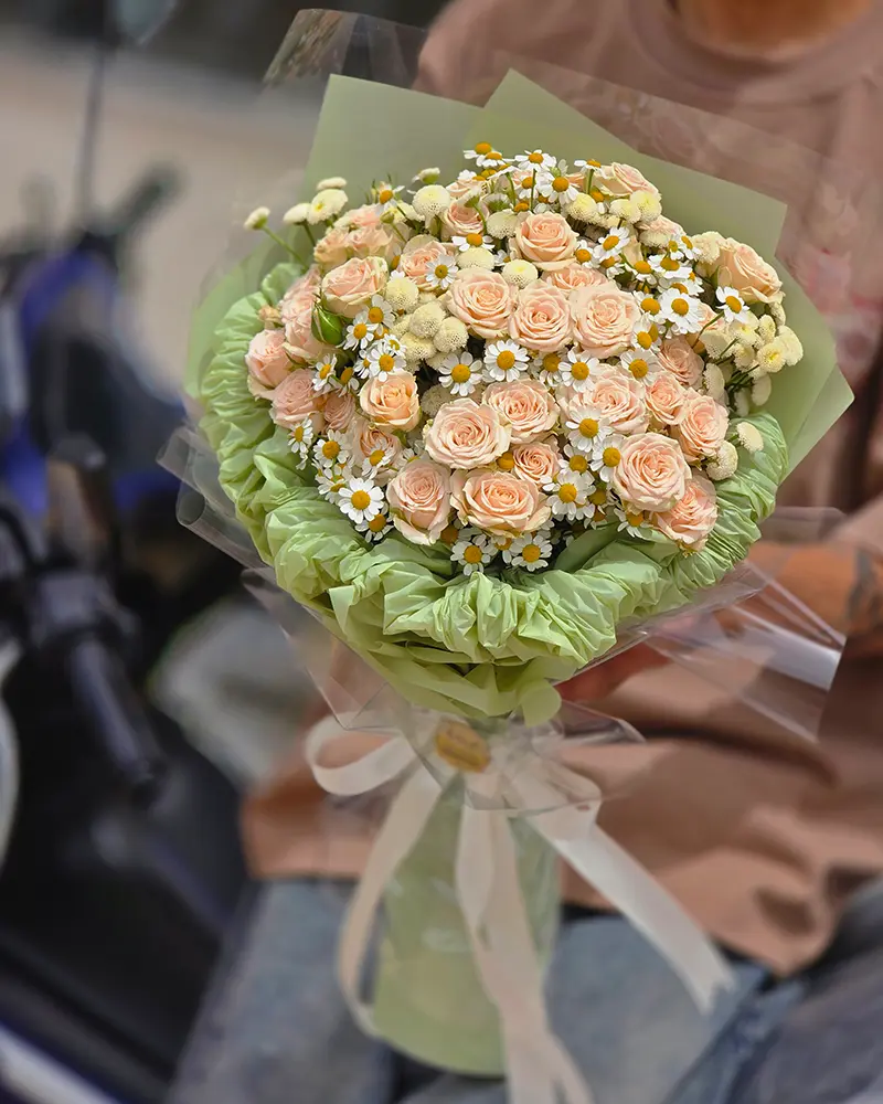 دسته گل هدیه رز هلویی با بستهبندی سبز و روبان سفید